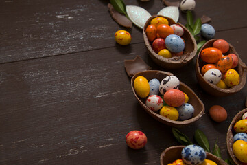 Wall Mural - Easter eggs hunt concept with chocolate eggs on wooden background copy space