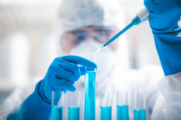 Wall Mural - researchers scientist working analysis with blue liquid test tube in the laboratory, chemistry scien