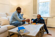© Lynsey Weatherspoon/Creative Flame - African American gay couple has game night at home