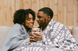 © Melissa Alexander/Creative Flame - Couple snuggled under blankets, cozy and warm