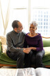© Lynsey Weatherspoon/Creative Flame - Senior Black couple sitting on couch at home