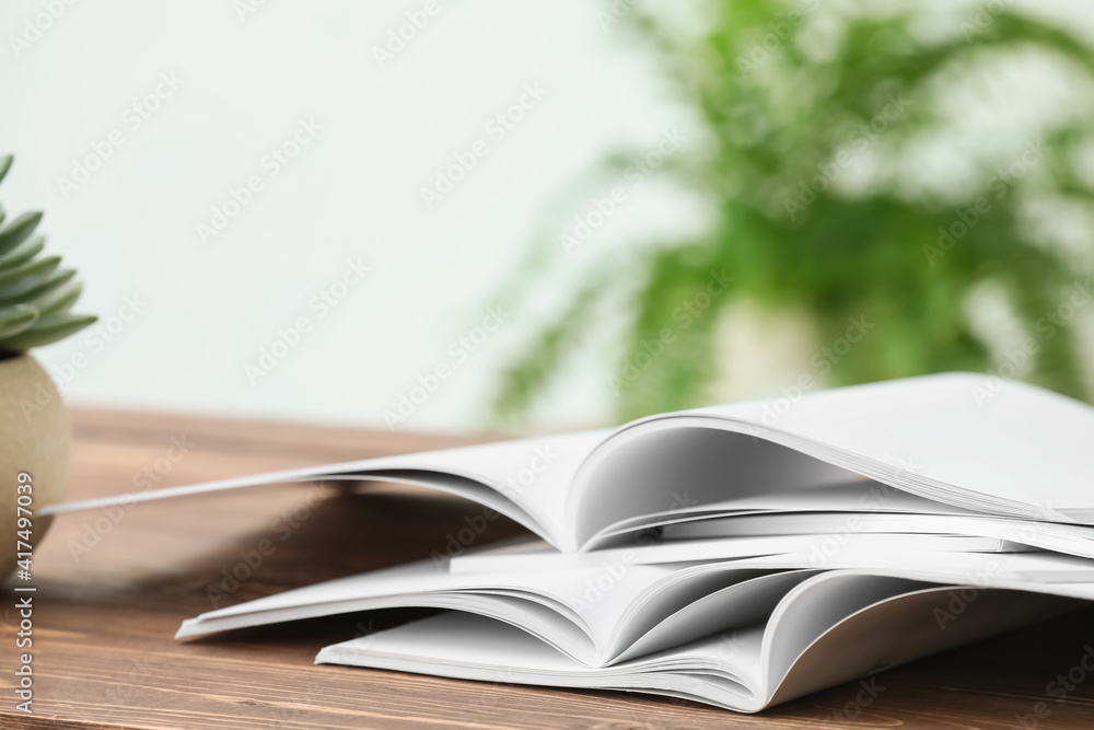 Open blank magazines on wooden table
