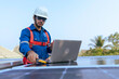 © Chatchawal - An Engineer use a laptop computer to examine the solar cell panel