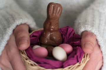 Wall Mural - Woman hands holding nest with Easter sweets