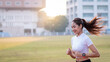 © EduLife Photos - A young Asian woman athlete runner jogging on running track in city stadium in the sunny morning to keep fitness and healthy lifestyle. Young fitness woman runs on stadium track. Sport and recreation