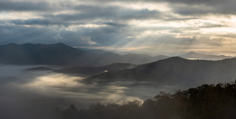 Wall Mural - Dramatic autumn weather - with clouds, fog and morning sun rays  - in the Blue Ridge Parkway Mountains, Pounding Mill Overlook	