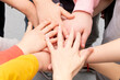 © ALEKSEI - many different children's hands and the teacher's hand are held together while playing at school during recess
