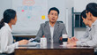 © tirachard - Millennial Asia businessmen and businesswomen meeting brainstorming ideas about new paperwork project colleagues working together planning success strategy enjoy teamwork in small modern night office.