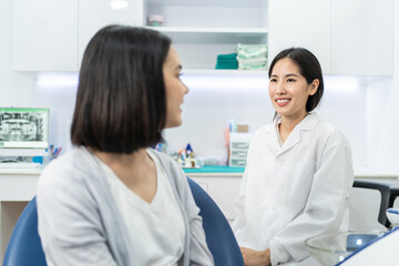 Wall Mural - Asian dentist giving advice to patient girl about oral care treatment.