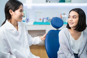 Wall Mural - Asian dentist giving advice to patient girl about oral care treatment.