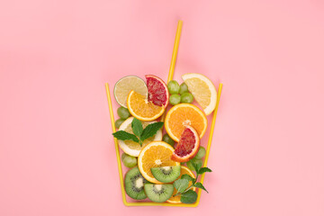 A glass made of differents fruits on colorful background. Minimalism design concept.