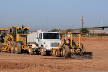 Water truck and excavators parked at construction site