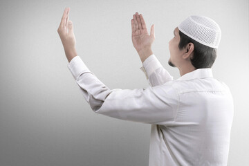 Wall Mural - Asian Muslim man praying with prayer beads on his hands