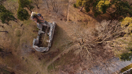 Aerial top view of a ruined abandoned building in a dense forest