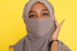 © faishalabdula - Fashion portrait of young beautiful asian muslim woman with wearing hijab isolated on yellow background.