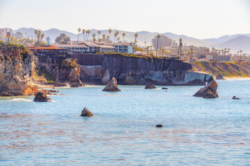 Wall Mural - Pismo Beach cliffs with palm trees,  and silhouette of hotels overlooking the Pacific Ocean. San Luis Obispo County, California Central Coast