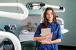© nazariykarkhut - Young doctor in a dental clinic. Portrait of young female doctor dentist with digital tablet in dental office
