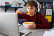 © gpointstudio - Boy eating breakfast during online classes