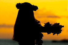 Silhouette Of A Hawaiian Woman Dancing During Sunset Near The Sea. 