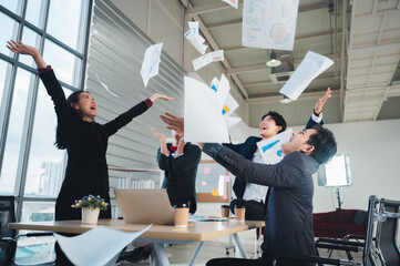 Wall Mural - Team of LGBT business people throws paper in joy of meeting their goals, achievements, achievements. LGBTQ business team concept, jumping to celebrate Asian ethnic success.