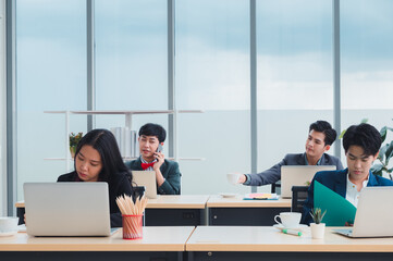 Wall Mural - Group of young business people sit at their desks with smiling colleagues together in the office.  Meeting business people  planning concept, laptop meeting ideas. Concentrate on work. LGBT teamwork.