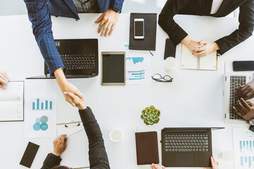 Wall Mural - Group of young business people working and communicating while sitting at the office desk together with colleagues sitting. business meeting. Desktop top view.