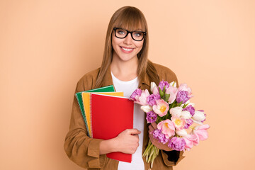 Sticker - Photo of attractive happy charming young woman hold notes flowers isolated on pastel beige color background