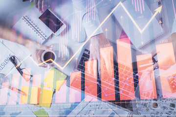 Multi exposure of man's hands typing over computer keyboard and forex graph hologram drawing. Top view. Financial markets concept.