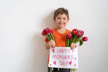 Wall Mural - Cheerful happy child with tulips flower bouquet. Smiling little boy on white background.