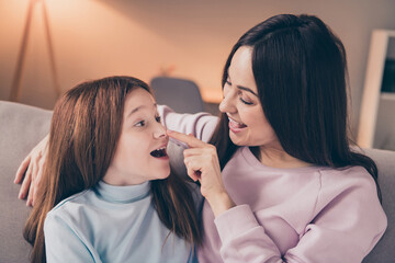 Wall Mural - Close-up portrait of attractive careful funny cheerful girls daughter mommy sitting on divan cuddling at house flat indoor