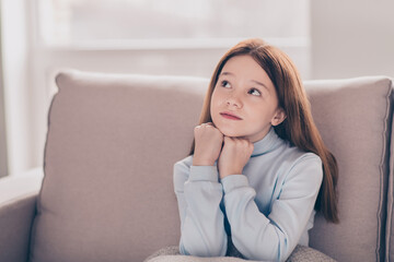 Wall Mural - Portrait of attractive minded dreamy preteen girl sitting on divan rest creating clue fantasizing at house flat indoor