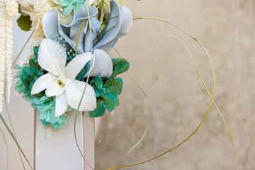 floral center detail with eucalyptus leaves and preserved flower on gray cement background