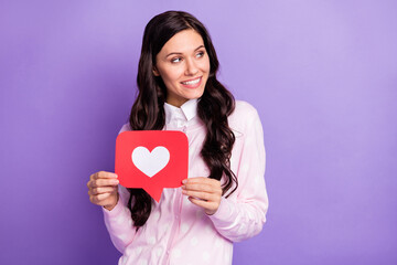 Sticker - Portrait of lovely cheerful wavy-haired girl holding in hand paper figure like looking aside copy space isolated on violet color background