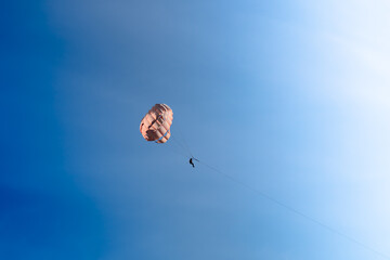 Parasailing in blue sky. Sports, active leisure, travel, vacation concept