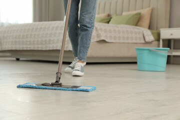 Sticker - Woman cleaning floor with mop at home, closeup