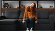 © LIGHTFIELD STUDIOS - Pensive teen girl sitting on couch near smartphone