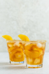 Wall Mural - Tropical orange iced tea, summer party drink in glasses. Space for text.