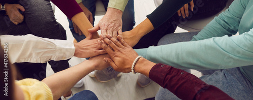 People of different ages and nationalities fold their hands on each other, symbolizing their unity and support. Team of people who are set up for productive work and a positive result. Close up. © Studio Romantic