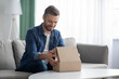 © Prostock-studio - Happy man unpacking delivery box, home interior