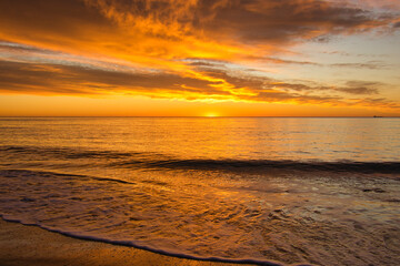 Wall Mural - A beautiful sunrise from the shore of the beach
