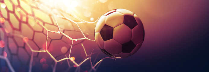 Poster - Soccer ball in the net in the sunbeams. Golden background