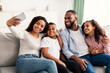 © Prostock-studio - Portrait of african american family taking a selfie together at home