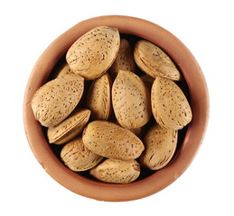 Wall Mural - Almond nuts in shells, kernels in clay pot isolated on white background, top view