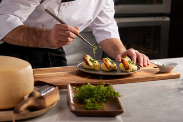 Cropped photo Close-up hands of male cook adding greens finishing dish, decorating meal in the end. gastronomy, food, nutrition, cafe concept