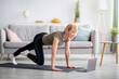 © Prostock-studio - Online sports during home isolation. Fit mature lady doing exercises in front of laptop indoors, copy space