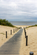 Beautiful Pathway On The Sandy Beach Leading To The Ocean Under The Cloudy Sky