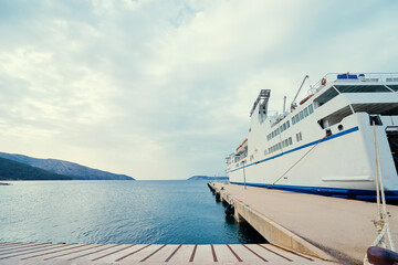 Wall Mural - Ferryboat loading or unloading by a port pier. Concept of transportation and traveling.