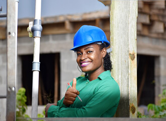 An attractive African Nigerian female construction and architectural engineer with blue safety helmet 