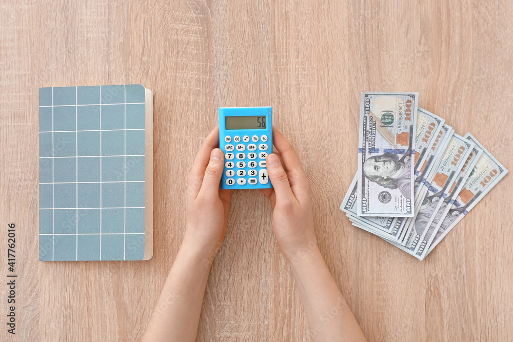 Woman counting expenses at table