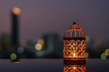 Golden lanterns with dusk sky and city bokeh light background for the Muslim feast of the holy month of Ramadan Kareem.